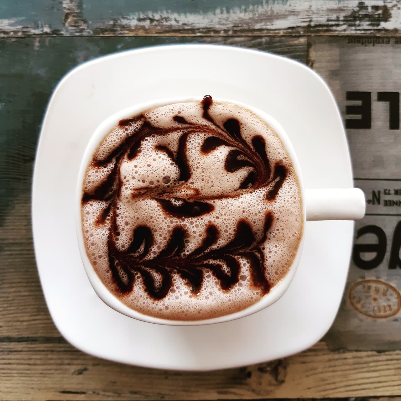 A hot chocolate with chocolate drizzled through the foam