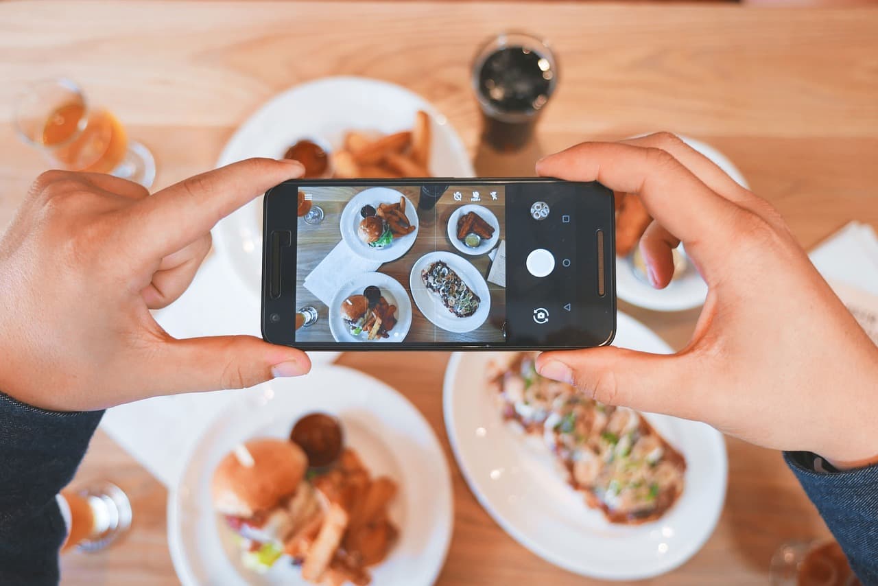 Someone photographing a brunch table on their phone